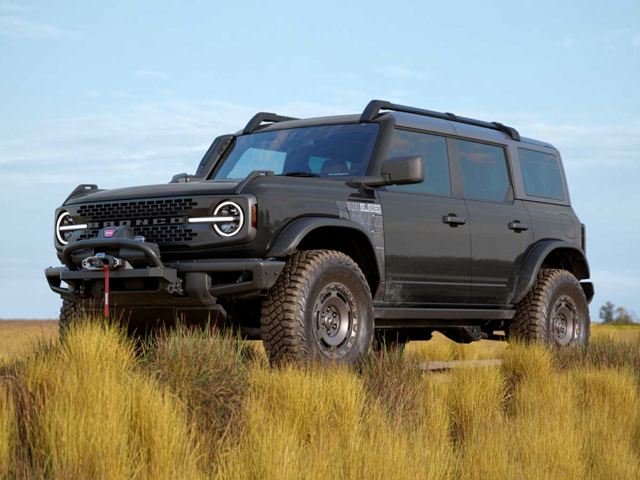 An image of a black Ford Bronco sitting in a field, ready to blaze some trails. 