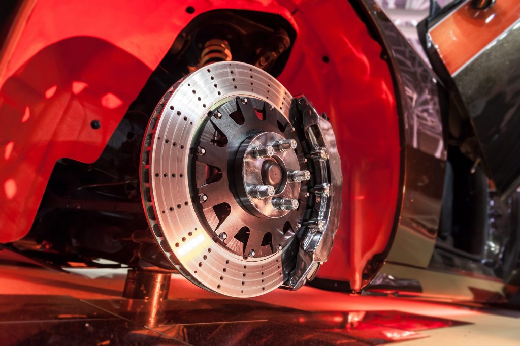 An image of high performance brakes on a bright red American muscle car. 