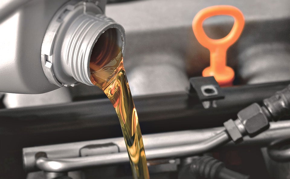 A picture of fresh oil being poured into an engine. 
